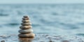 Serene stone stack on beach with calm ocean background for tranquility Royalty Free Stock Photo