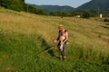 Serene Summer Scene: Farmer Taming the Tall Grass with Trimmer in Sun-Kissed Meadow Royalty Free Stock Photo