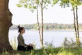 Serenity in Nature: Young Woman Meditating by the Forest Lake