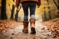 Serene unrecognizable woman walking on autumn forest path surrounded by natures beauty