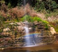 Serene Waterfall with Rainbow in Lush Green Forest