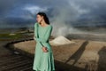 Serene Woman in Green Dress Standing by Steam in Nature