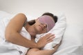 Serene woman in sleep mask pillow beneath blanket, embodying the essence of healthy sleep habits.