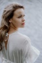 A Serene Woman in a White Dress by a Tranquil Body of Water Royalty Free Stock Photo