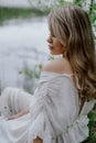 A Serene Woman in a White Dress by a Tranquil Body of Water Royalty Free Stock Photo