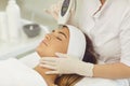 Woman receiving ultrasound apparatus facial cleaning in beauty salon Royalty Free Stock Photo