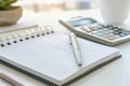 A serene workspace with a notebook, pen, and calculator inviting productivity under morning light Royalty Free Stock Photo