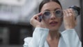 Serene young woman in goggles standing outdoors