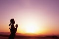 Serene young woman with hands together in prayer pose in the desert in China, silhouette, profile, sun setting Royalty Free Stock Photo