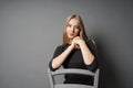 Serene young woman sitting astride on chair