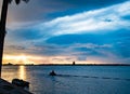 End of day, dusk little motor boat moving into the glowing sun. View of Sarasota Bay, Florida near Siesta Key Beach at sunset Royalty Free Stock Photo