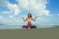 Young attractive and athletic woman in balance yoga posture at beautiful beach doing relaxation and meditation exercise under a