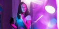 Cinematic portrait of handsome young woman in neon lighted interior