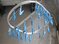 Serie of blue clothespins hanging on a white platic frame in the streets of Naples