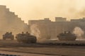 Army tanks shooting and driving in the desert town in war and military conflict. Military concept of war and explosions