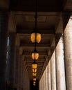 Series of ceiling hanging lamps in a corridor old building with columns in Paris, France Royalty Free Stock Photo