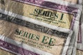 Series I and Series EE US Savings Bonds with 100 dollar bill overlay. Savings bonds are debt securities issued by the US