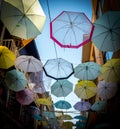 Series of multi-colored umbrellas hanging above the street