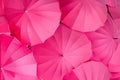 Series of pink umbrellas all together seen from above composing a abstract background