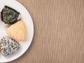 A series of shots of onigiri of various shapes and fillings on a plate. Top view. Japanese rice ball