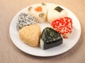 A series of shots of onigiri of various shapes and fillings on a plate. Top view. Japanese rice ball