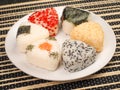 A series of shots of onigiri of various shapes and fillings on a plate. Top view. Japanese rice ball