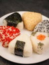 A series of shots of onigiri of various shapes and fillings on a plate. Top view. Japanese rice ball