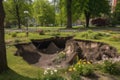 series of sinkholes in a city park, with trees and flowers growing around them