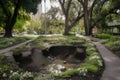 series of sinkholes in a city park, with trees and flowers growing around them