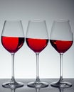 Series of three glasses of wine on gray Royalty Free Stock Photo