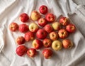 A series of tiny, freshly washed apples scattered on a white linen cloth, reflecting simplicity and naturality Royalty Free Stock Photo