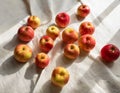 A series of tiny, freshly washed apples scattered on a white linen cloth, reflecting simplicity and naturality Royalty Free Stock Photo