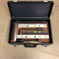 A series of tools for alignment and leveling displayed in a neat organized toolbox on a concrete floor