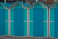 A series of turquoise beach sheds with blue wooden doors in a winter day Italy, Europe Royalty Free Stock Photo