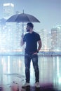 Serine man holding umbrella in abstract metropolis