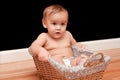 Serious 9 month old baby in basket Royalty Free Stock Photo