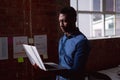 Serious african american businessman standing in office holding and looking at laptop Royalty Free Stock Photo