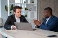 Serious African American businessman talking to colleague explaining project Royalty Free Stock Photo