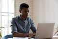 Serious African American businessman using laptop, working on project Royalty Free Stock Photo