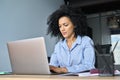 Serious African American businesswoman working typing using pc laptop.