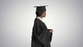 Serious African American female graduate walking with diploma on