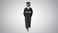 Serious African American female graduate walking with diploma on