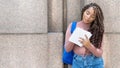 Serious african american female university student with backpack writing notes Royalty Free Stock Photo