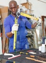 serious African American glazier using multifunction angle finder level for measuring glass size