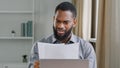 Serious African American man ethnic bearded businessman boss entrepreneur bookkeeper executive in office holding papers
