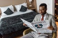 Serious african american man in suit reading business newspaper