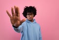 Serious African American teen guy gesturing STOP on pink studio background. Negative opinion concept Royalty Free Stock Photo