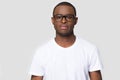 Serious african male wearing glasses white t-shirt posing indoors Royalty Free Stock Photo