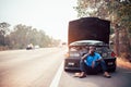 Serious african man call help by smartphone near his old broken car  with raised hood on the highway road Royalty Free Stock Photo