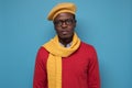 Serious African man in glasses, scarf and yellow hat looking at camera Royalty Free Stock Photo